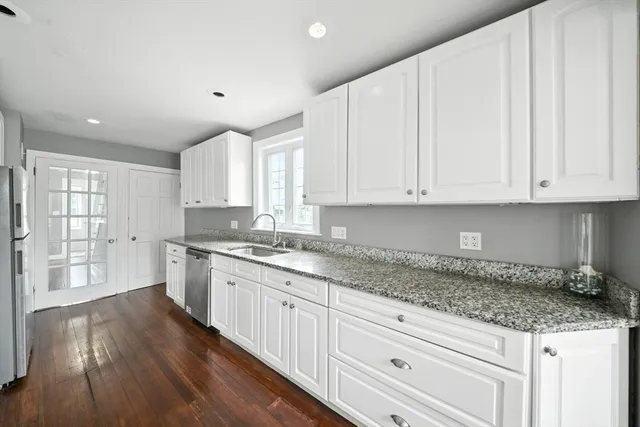 a kitchen with granite countertop wooden cabinets and white appliances