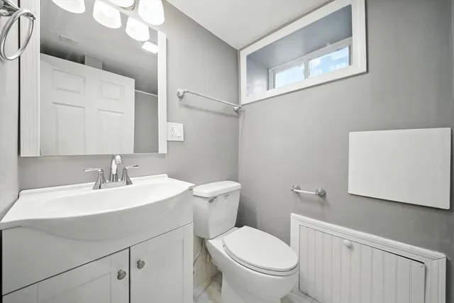 a bathroom with a toilet a sink and a mirror