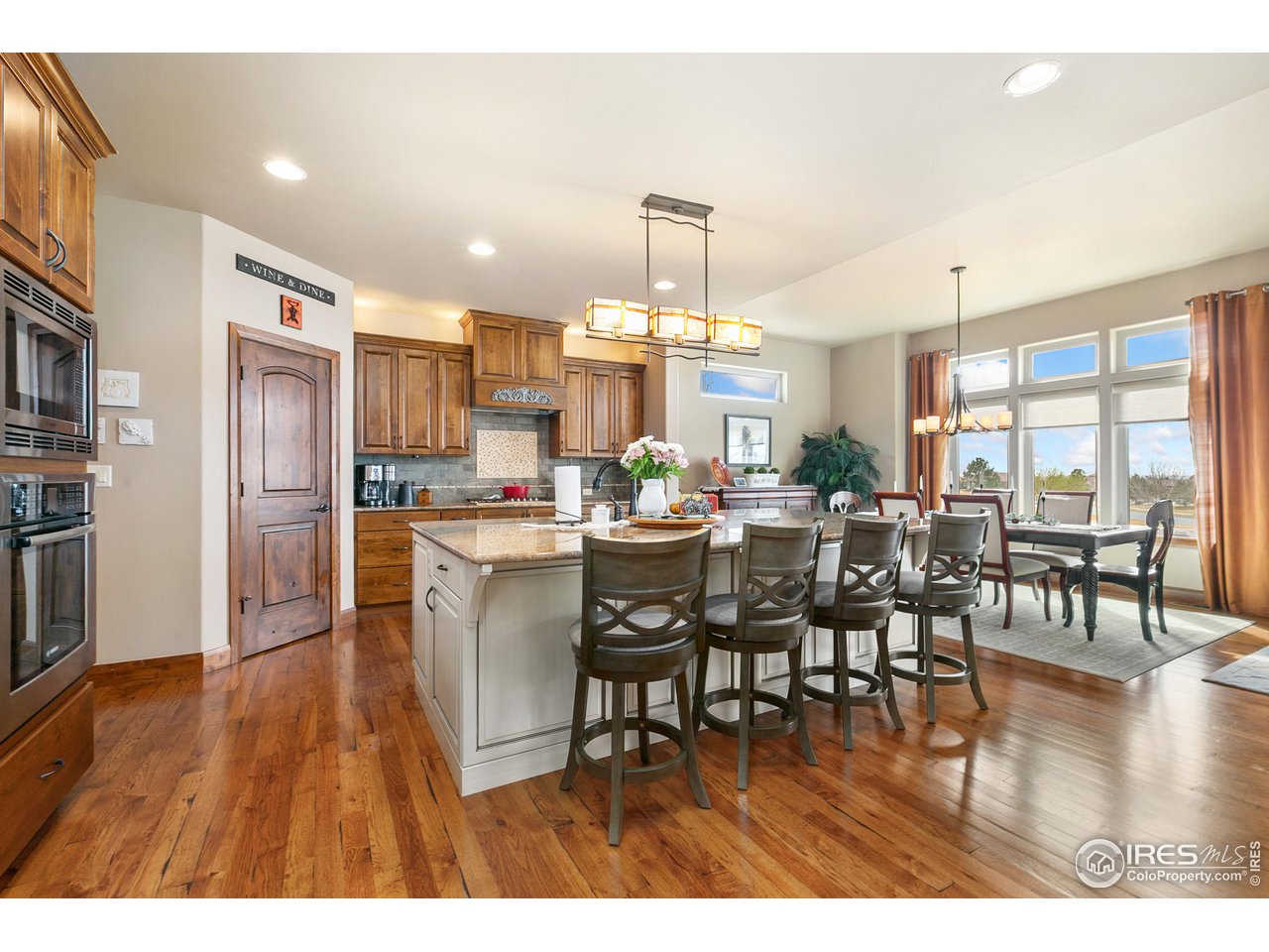 6701 Clovis Court Timnath, CO 80547 - Photo 2 of 40 a dining room with stainless steel appliances kitchen island granite countertop a dining table chairs and granite counter tops