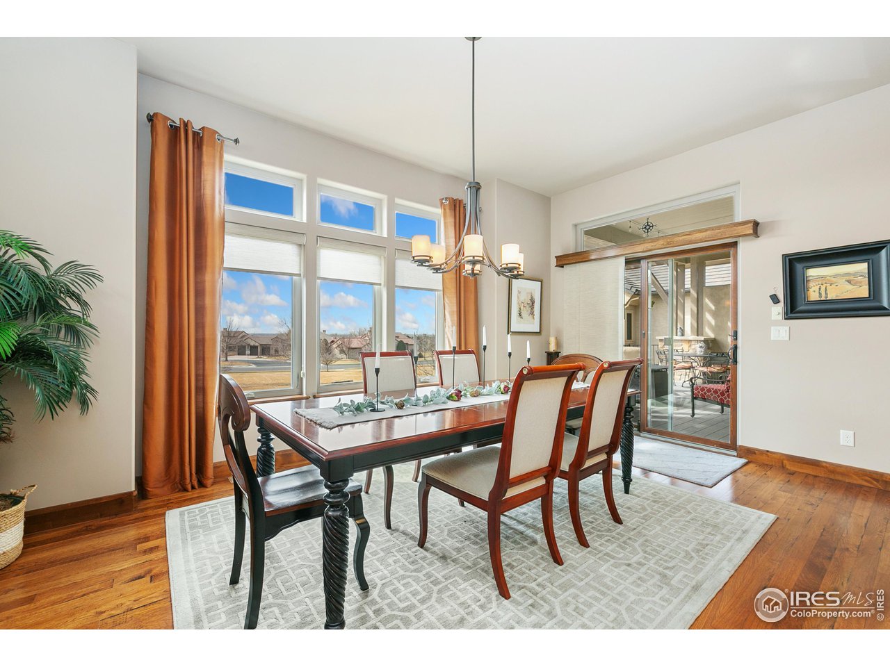 6701 Clovis Court Timnath, CO 80547 - Photo 3 of 40 a dining room with furniture a chandelier and wooden floor