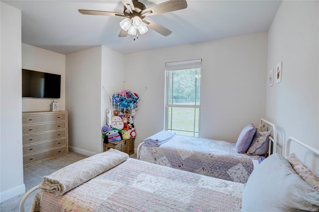1355 Jay Bird Road Springtown, TX 76082 - Photo 32 of 40 a bedroom with a bed and a flat screen tv