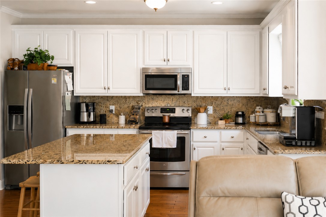 190 Fred Bradford Road Iva, SC 29655 - Photo 9 of 32 This bright kitchen features white cabinetry and granite countertops, creating a welcoming and functional space.