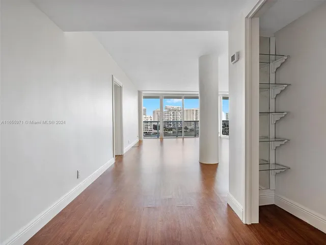 a hallway with wooden floor fireplace and windows