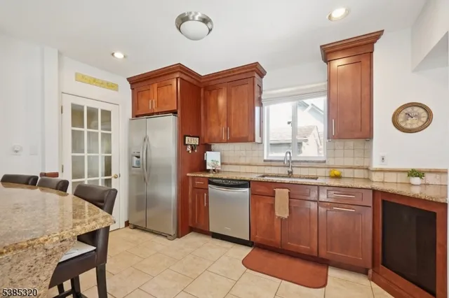 a kitchen with granite countertop a sink stainless steel appliances and cabinets