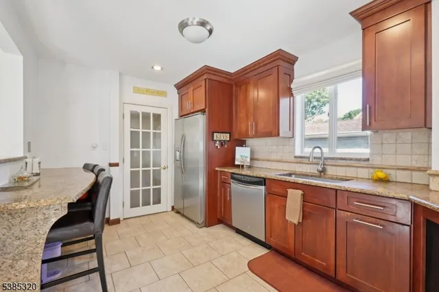 a kitchen with granite countertop a sink stainless steel appliances and cabinets