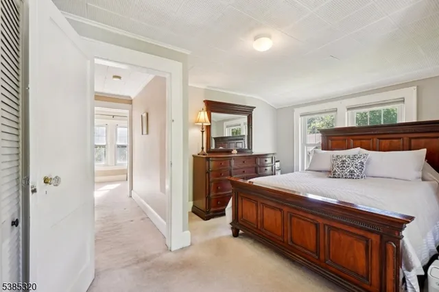 a bedroom with a bed and a refrigerator