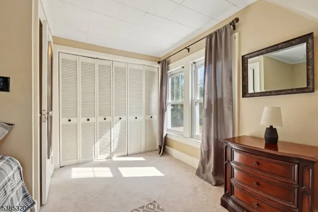 a view of a hallway with closet and mirror