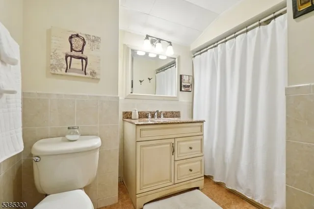 a bathroom with a toilet sink vanity and mirror