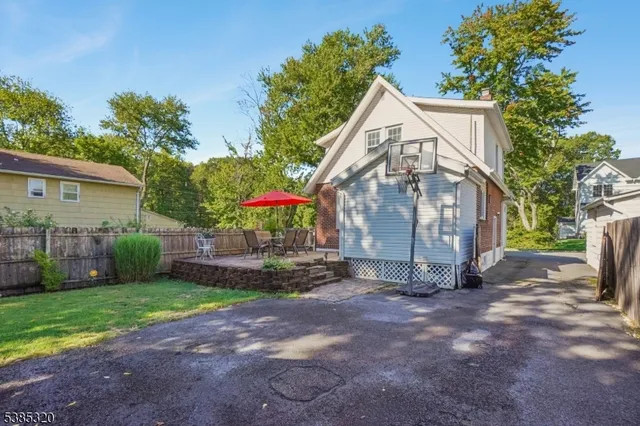 a view of a house with a yard and a large tree