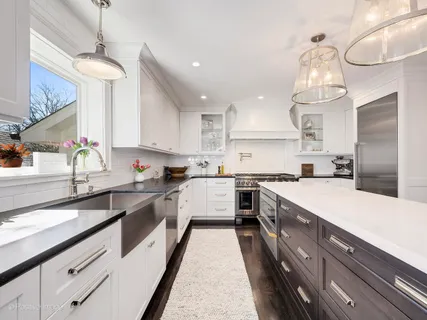 a large kitchen with granite countertop lots of counter space sink and refrigerator