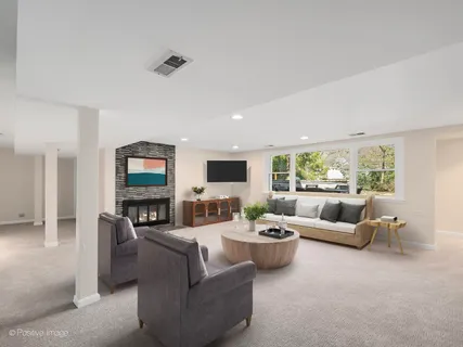 a living room with furniture flat screen tv and a large window