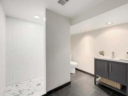 a bathroom with a sink a toilet and shower