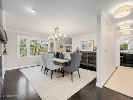 a view of a dining room with furniture a chandelier and wooden floor