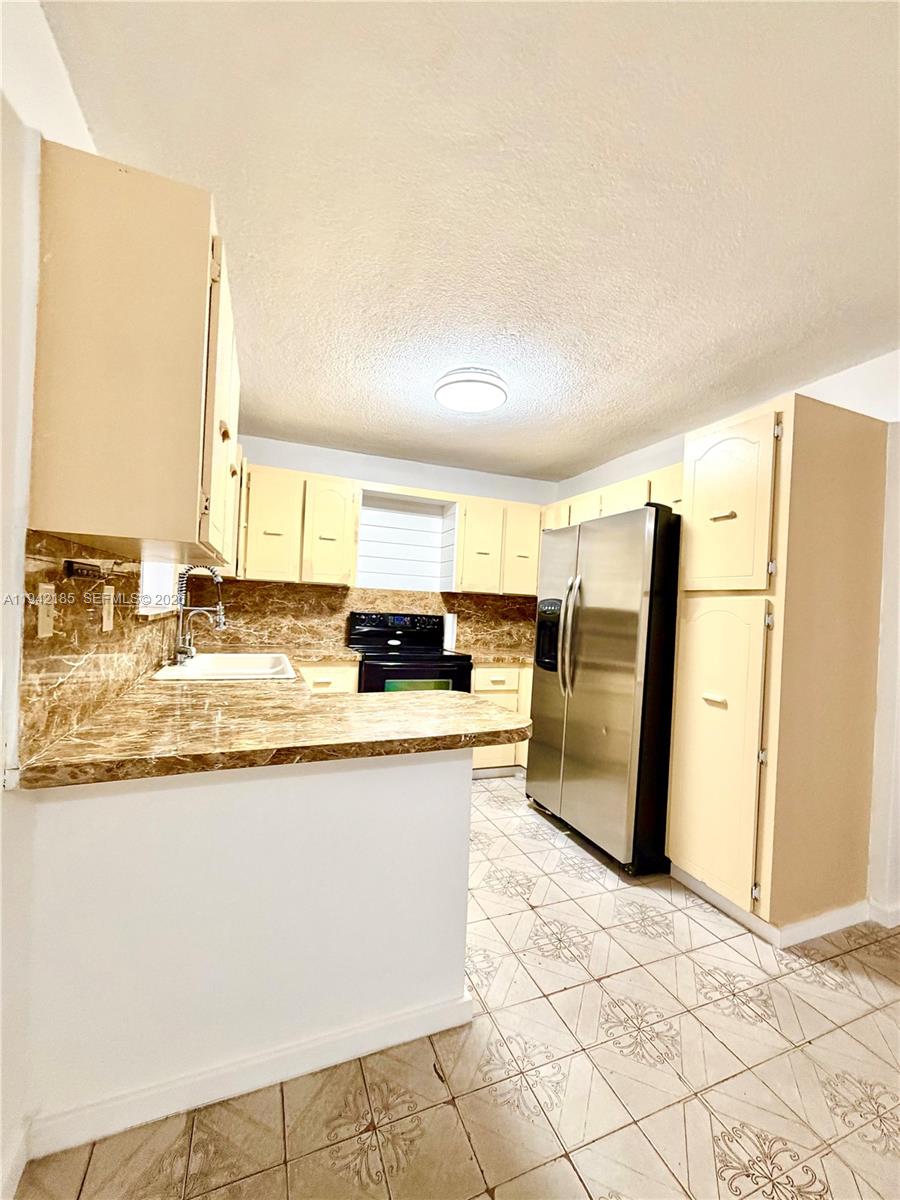958 East 21st Street Hialeah, FL 33013 - Photo 2 of 16 a kitchen with stainless steel appliances granite countertop a refrigerator and a sink