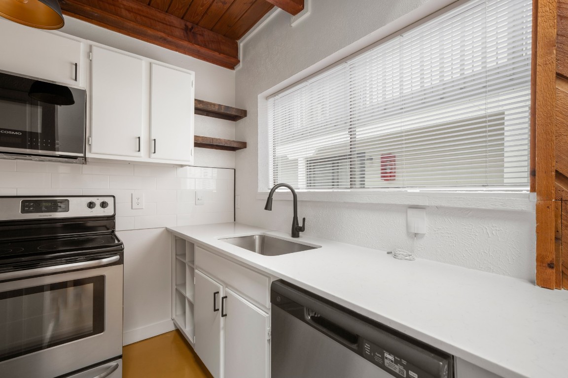 a kitchen with stainless steel appliances a sink stove and microwave