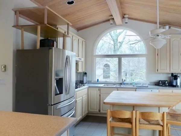 a kitchen with stainless steel appliances granite countertop a refrigerator a sink a stove and island