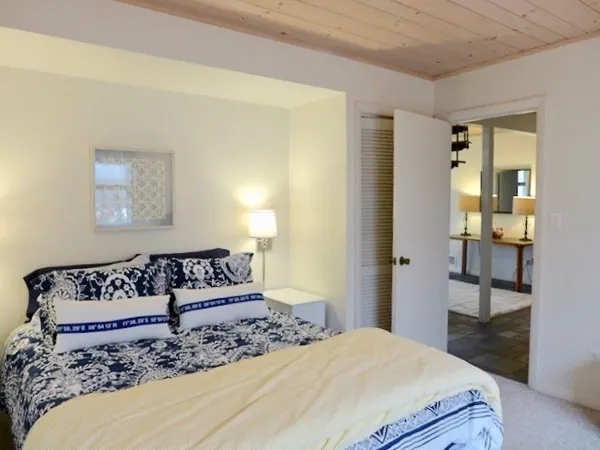 a bedroom with a bed and a painting on the wall