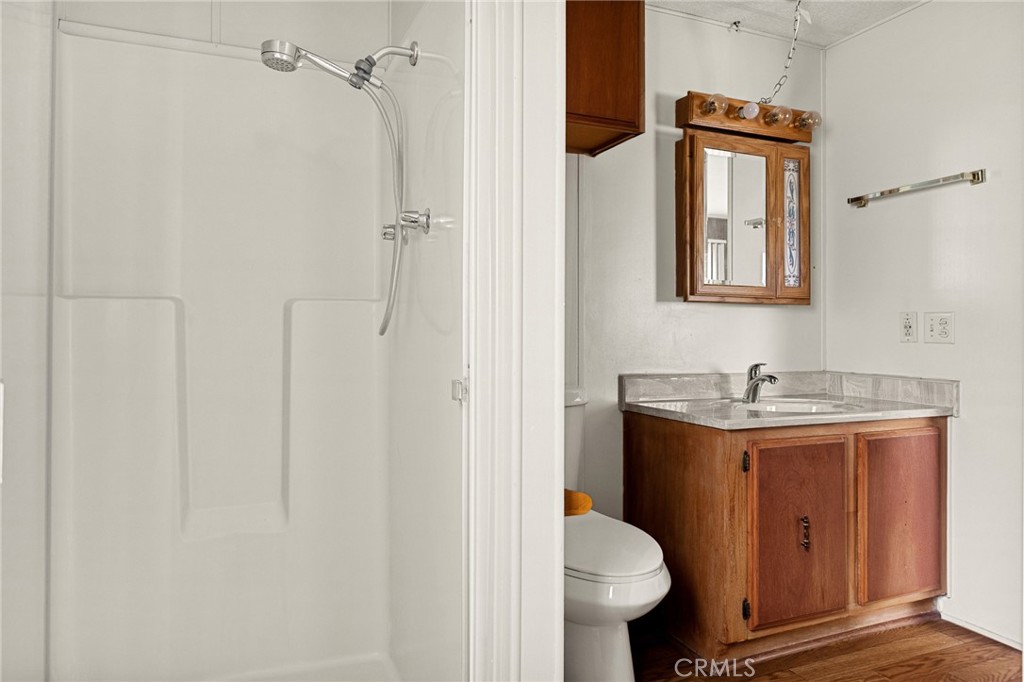 12367 4th Street Yucaipa, CA 92399 - Photo 13 of 19 a bathroom with a granite countertop toilet sink and mirror