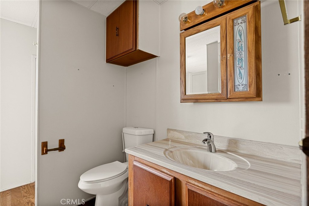 12367 4th Street Yucaipa, CA 92399 - Photo 10 of 19 a bathroom with a granite countertop toilet sink and mirror