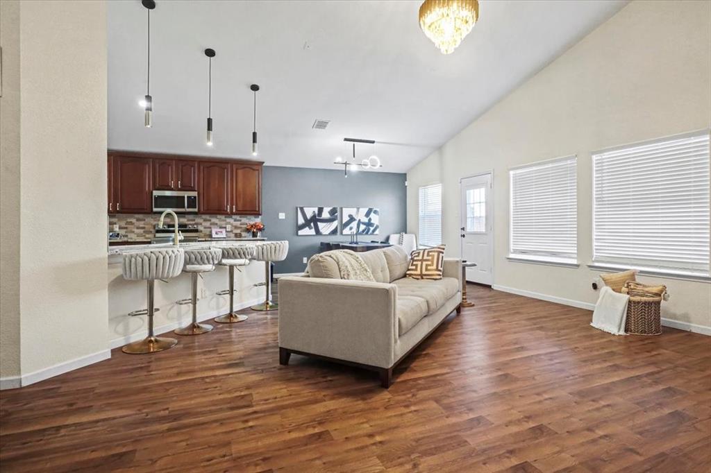 1412 Cheyenne Road Wylie, TX 75098 - Photo 7 of 24 Living room with high vaulted ceiling, a chandelier, and dark wood-type flooring