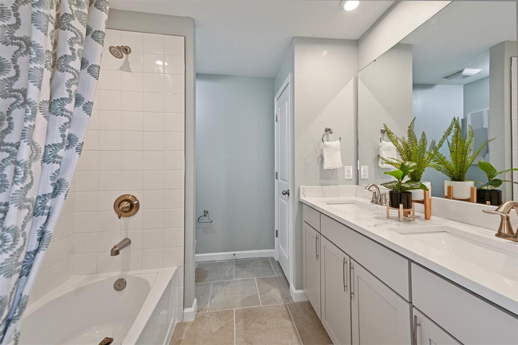 3358 Timber Xing Avenue Brandon, FL 33511 - Photo 19 of 22 a bathroom with a granite countertop sink a mirror a bathtub and shower