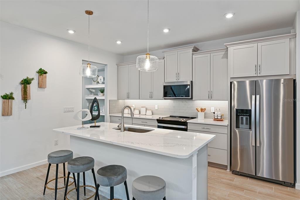3358 Timber Xing Avenue Brandon, FL 33511 - Photo 4 of 22 a kitchen with stainless steel appliances granite countertop a kitchen island a stove a table and chairs