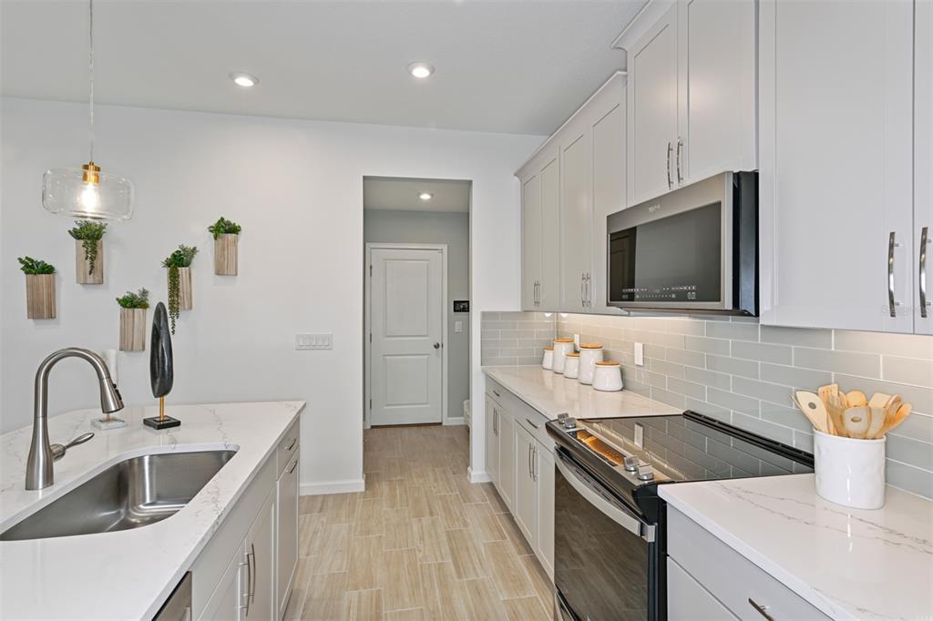 3358 Timber Xing Avenue Brandon, FL 33511 - Photo 5 of 22 a kitchen with a sink and a stove top oven with wooden floor
