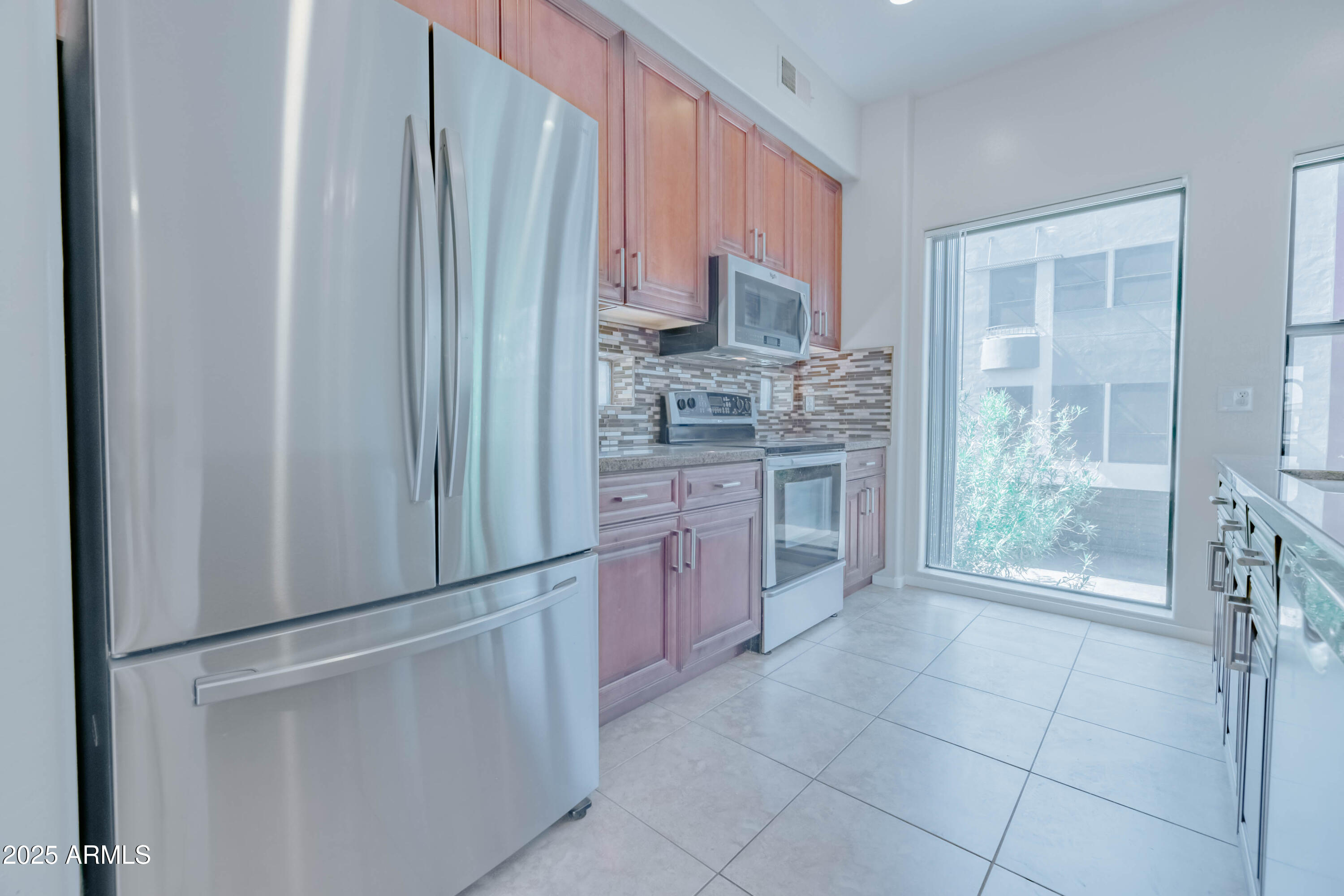 4739 East Culver Street Phoenix, AZ 85008 - Photo 14 of 55 a kitchen with stainless steel appliances a refrigerator sink and cabinets