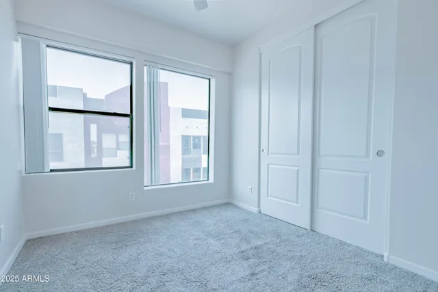 an empty room with windows and closet