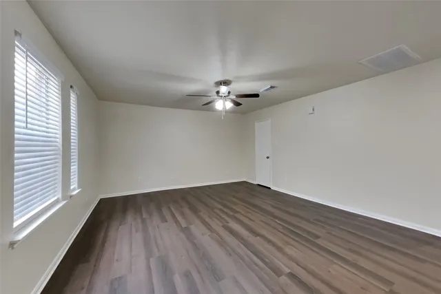wooden floor in an empty room with a window
