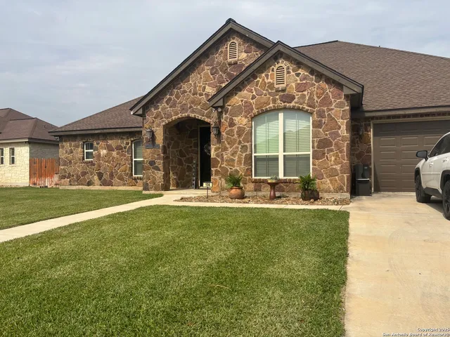 a front view of a house with a garden and plants