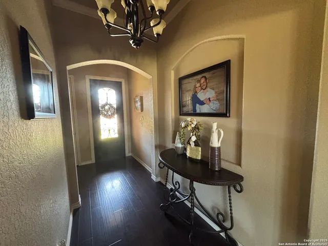 a room with lots of white furniture and a mirror