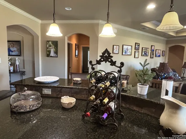 a kitchen with stainless steel appliances granite countertop a stove top oven a sink a dining table and chairs