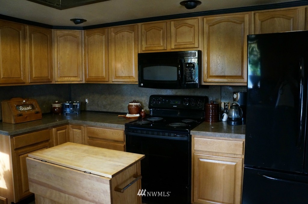 4435 Maytown Road Southwest Olympia, WA 98512 - Photo 4 of 25 a kitchen with a sink and a refrigerator