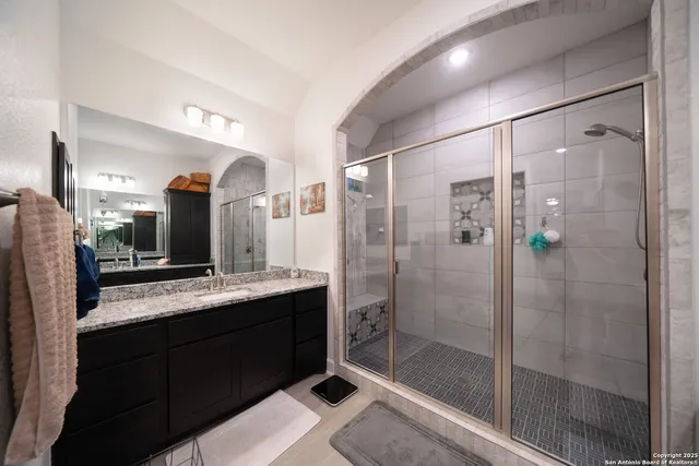 a bathroom with a granite countertop sink a toilet and shower