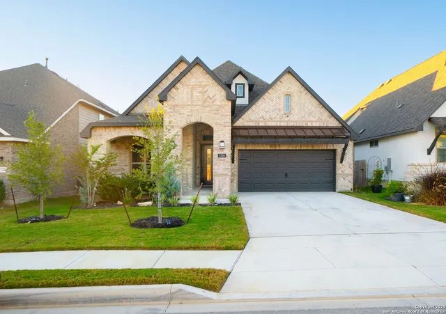 a front view of a house with a yard and garage