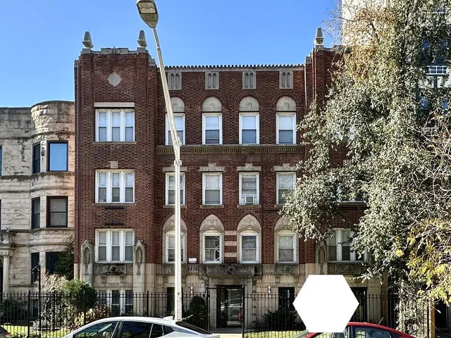a front view of a residential apartment building with a yard