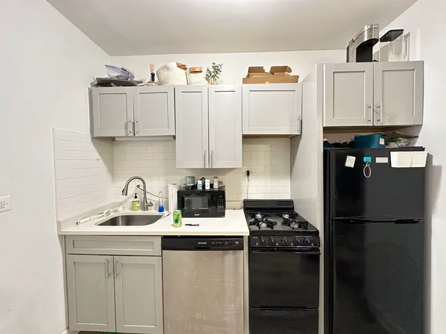 a kitchen with appliances a sink and cabinets