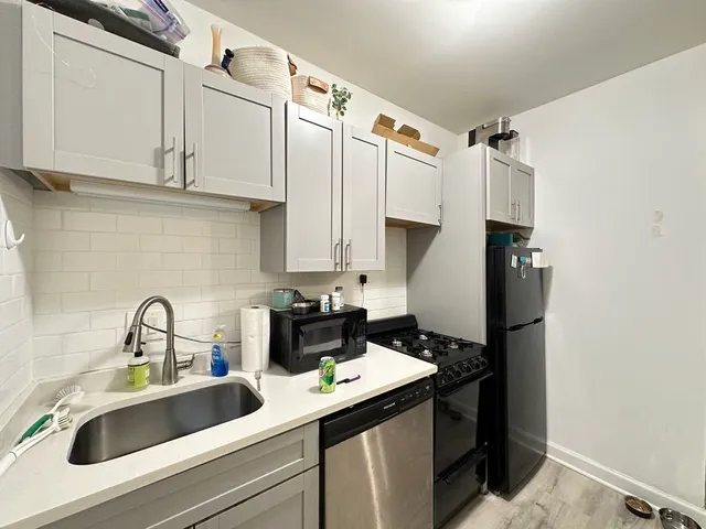 a kitchen with stainless steel appliances sink refrigerator and cabinets