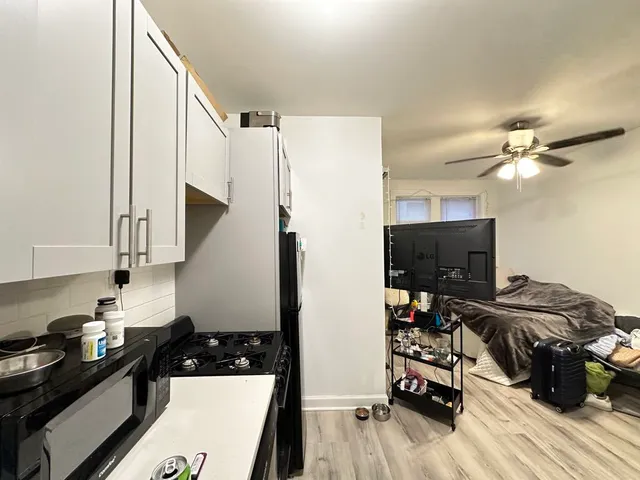 a kitchen with a refrigerator and a stove top oven
