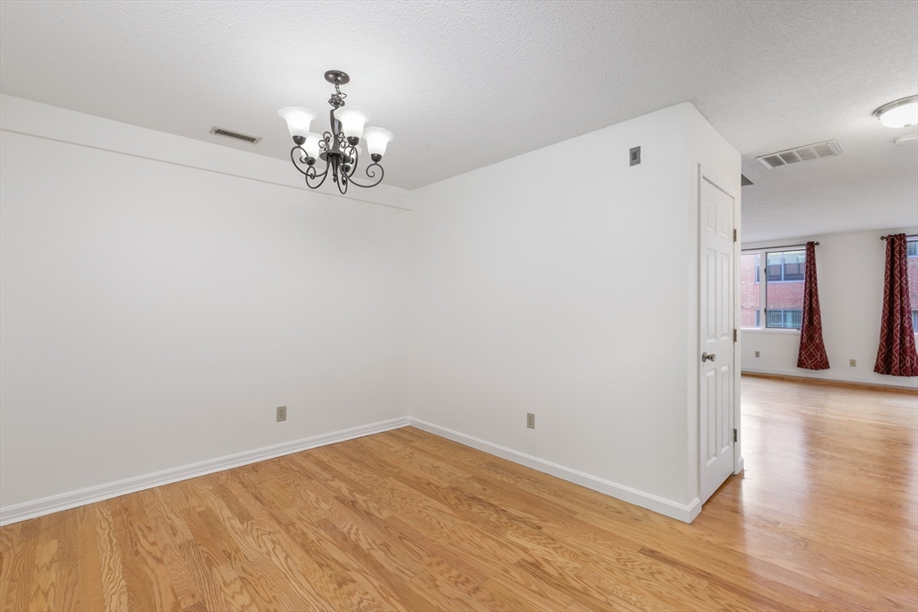 128 Warren Street, Unit 12 Lowell, MA 01852 - Photo 7 of 24 a view of a room with wooden floor and chandelier