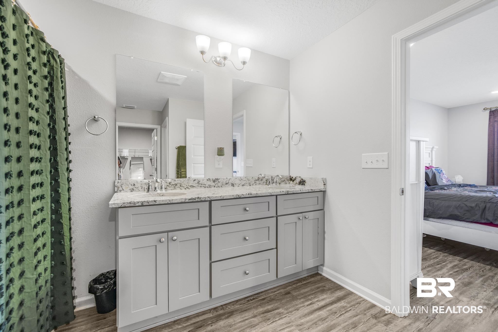 10738 Ridgeview Drive Mobile, AL 36608 - Photo 26 of 48 Ensuite bathroom featuring light wood-style flooring, double vanity, a shower with shower curtain, and a textured ceiling