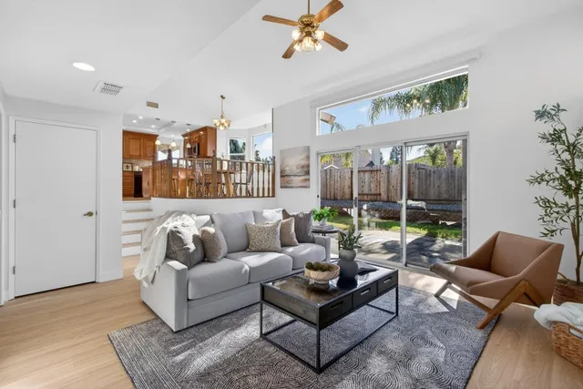 an empty room with wooden floor and ceiling fan