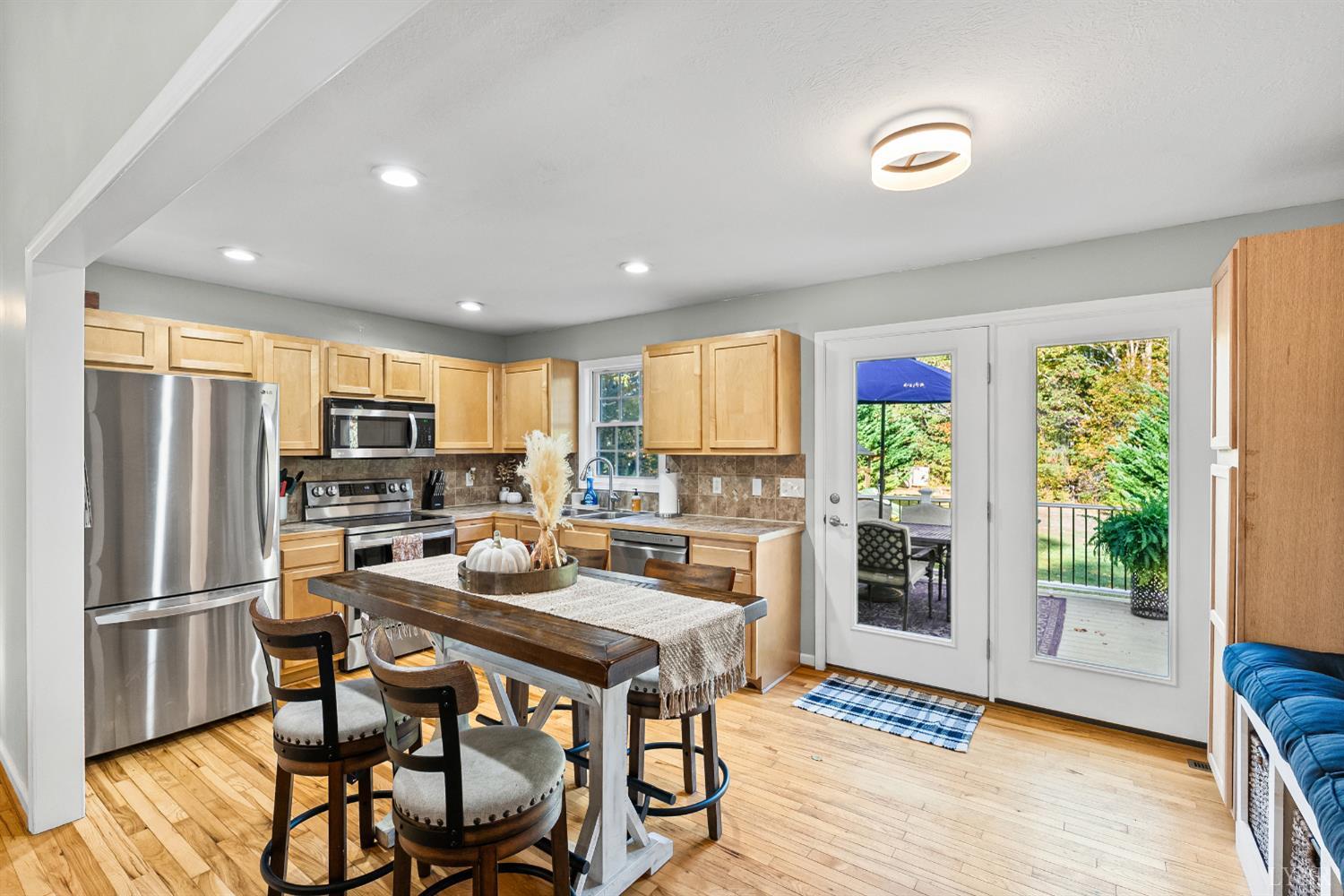 2739 Chilton Road Appomattox, VA 24522 - Photo 8 of 30 a kitchen with stainless steel appliances granite countertop a stove top oven a refrigerator and a dining table with wooden floor