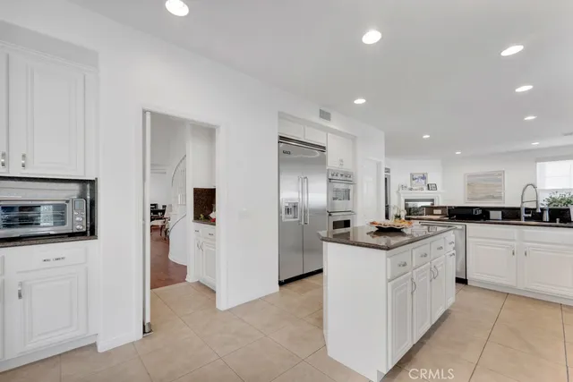 a kitchen with stainless steel appliances granite countertop a refrigerator and a stove top oven