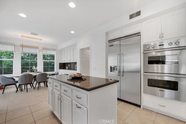 a kitchen with granite countertop a stove a sink and a refrigerator