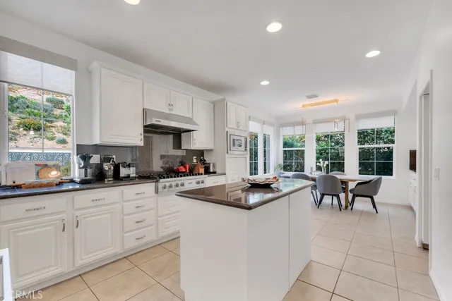 a kitchen with granite countertop a sink and white cabinets