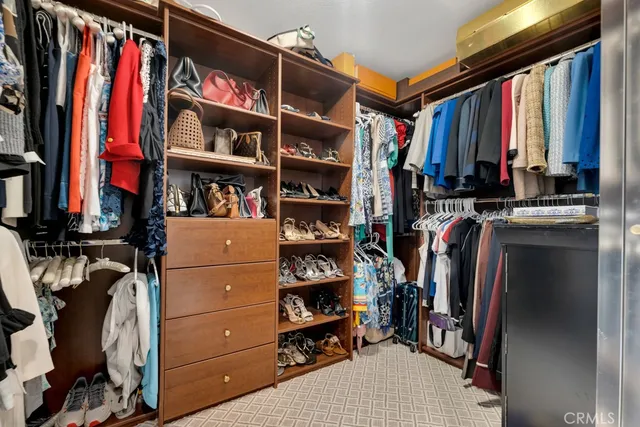 a view of walk in closet with clothes and shoes
