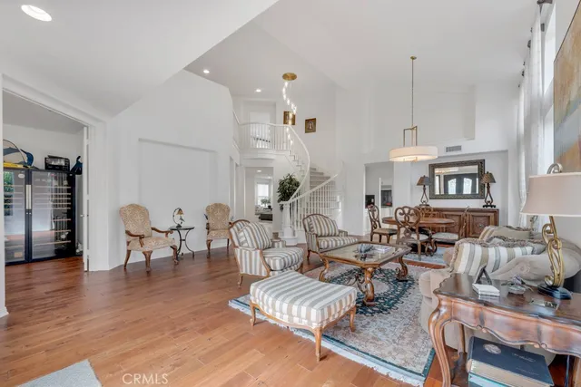 a living room with furniture kitchen view and a chandelier