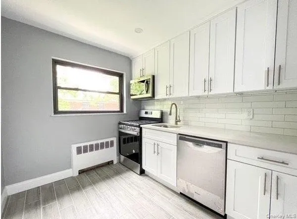 a kitchen with stainless steel appliances granite countertop a sink stove and cabinets